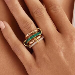 Stacked 18K gold diamond emerald ring worn on hand close-up detail shot showing layered gemstone bands