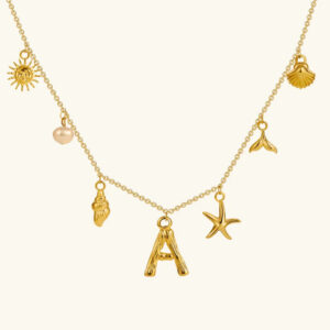 18K gold ocean initial charm necklace overhead flat lay display with starfish pearl sun and mermaid tail charms personalized letter pendant
