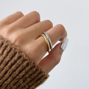Two-tone gold and silver stacked rings worn on female hand - minimalist dual-tone ring stack styling
