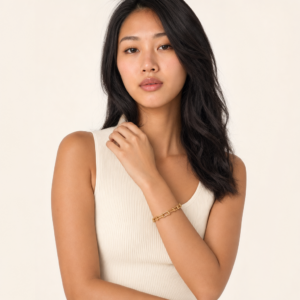 18K gold horseshoe link bracelet worn on model's right wrist half-body portrait wearing ivory white ribbed tank top