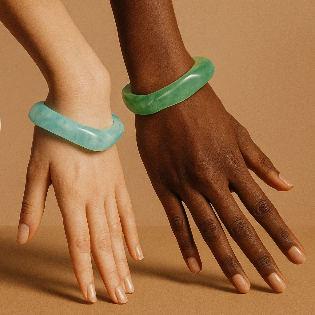 Two models wearing jade-like acrylic bangles in light cyan and emerald green, close-up wrist flat view showcasing smooth rounded square silhouette