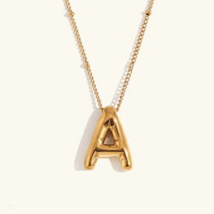 18K gold balloon initial letter A necklace flat lay product view with beaded chain