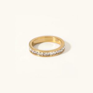 18K gold eternity ring with AAAAA diamond simulants, channel-set baguette cut stones, polished gold band, flat lay view