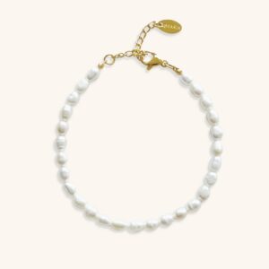 Freshwater pearl bracelet flat lay - white rice-shaped pearls on gold-toned chain against neutral background, showcasing delicate pearl clustering and stainless steel clasp design