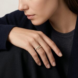 18K gold spiral diamond wrap ring worn on female hand side profile showing detail of gemstone setting and gold band texture