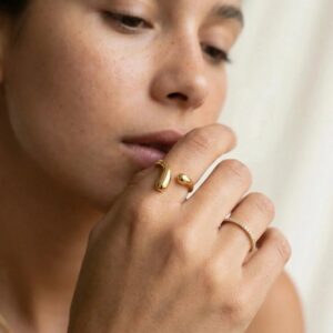 Gold and silver open twist rings stacked on woman's hand multiple fingers close-up styling