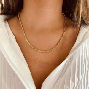 Woman wearing 18K gold rope chain necklace at collarbone with white pleated blouse demonstrating elegant styling on torso