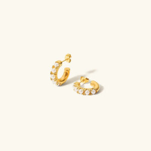 18K gold freshwater pearl huggie earrings flat lay with pearl details and gold hoop design