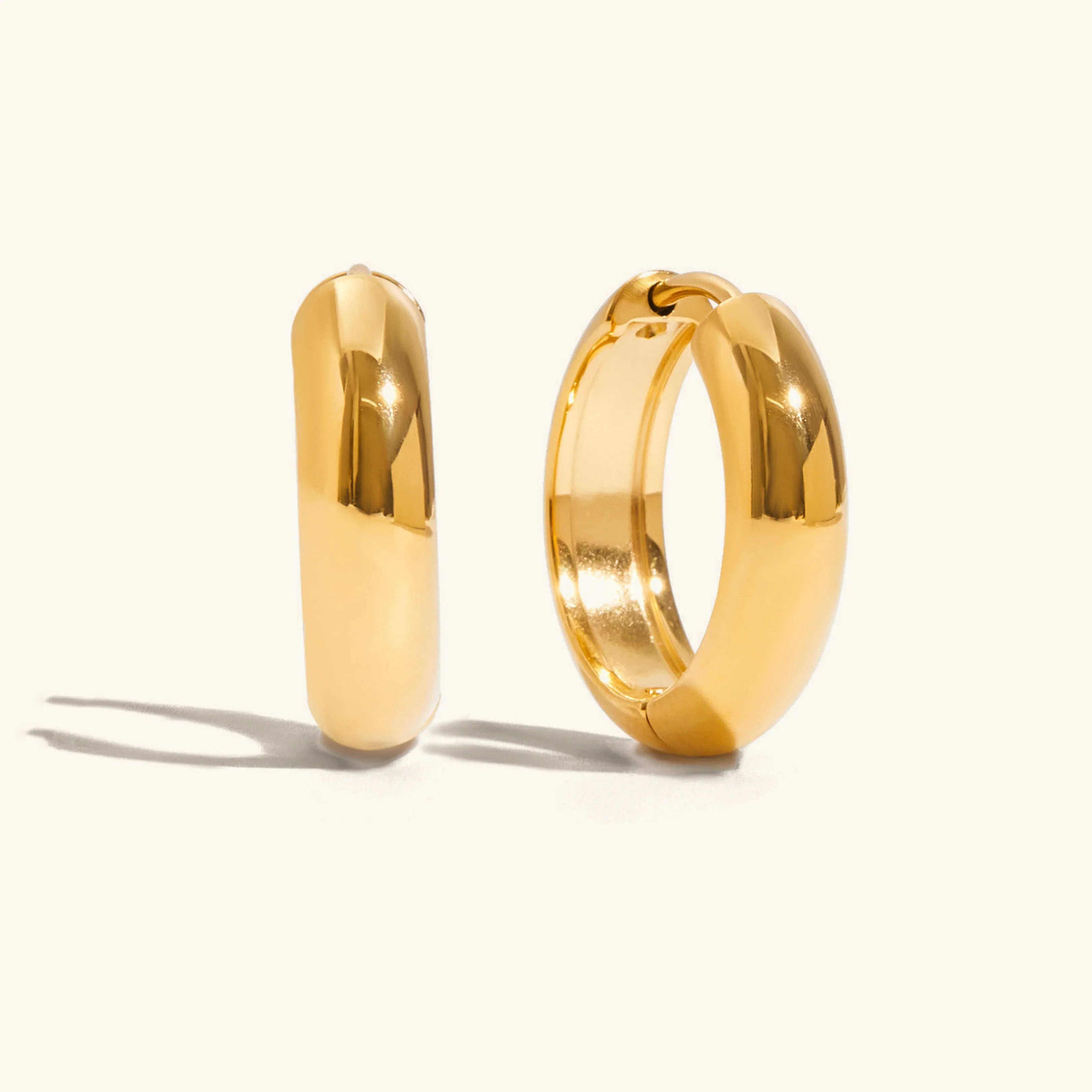 Thick round gold hoop earrings multiple sizes showing smooth polished texture and gold luster