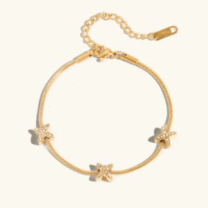 18K gold diamond cross herringbone bracelet flat lay top view showing three crystal-adorned star charms on delicate gold chain