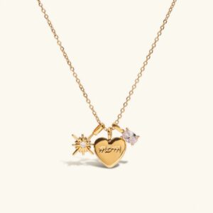 18K gold mom heart locket necklace with hand-engraved charm, cubic zirconia stone, and sunburst detail on white background flat lay view