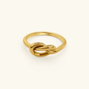 18K gold knot ring front flat lay view polished twisted design on plain beige background