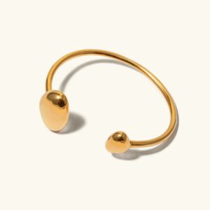 18K gold minimalist open cuff bracelet flat lay with polished oval terminals on plain background, top view showcasing bracelet design