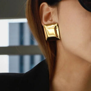 18K gold chunky pillow stud earrings on model ear close-up side profile glossy finish