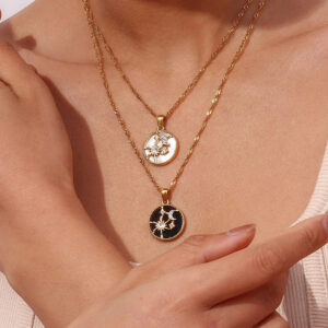 Layered 18K gold celestial necklaces worn on model neck close-up shot dual chain styling