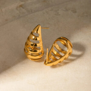 Close-up flat lay of 18K gold drop hoop stud earrings on matte surface showing curved hollow stripe details and post design