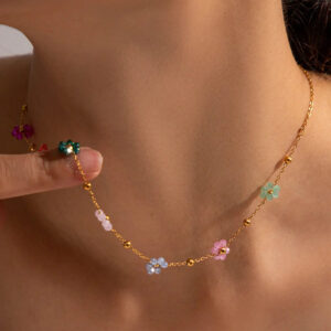 Close-up of 18K gold azalea necklace worn on female neck model showing delicate flower station design and slim gold chain fit at collarbone