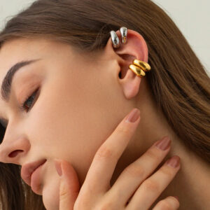 Layered ear styling with silver and gold ear cuffs on female model, side profile close-up showcasing mixed metal design and wear comfort