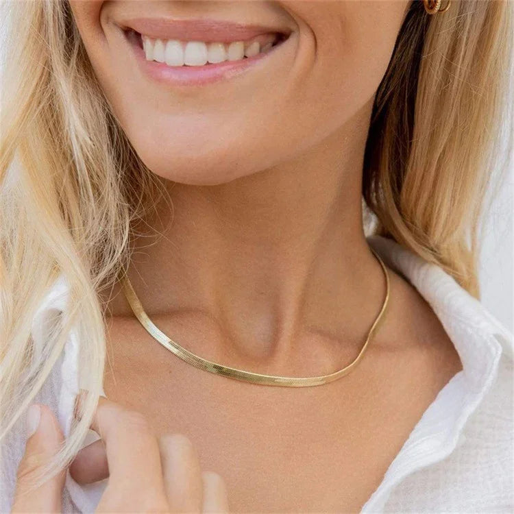 Medium-width 3mm gold herringbone necklace worn on model chest showing balanced chain presence and polish