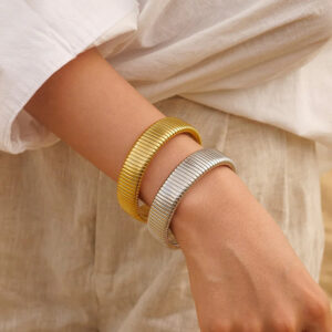 Gold and silver ribbed stretch bracelets worn on wrist casual linen style wide ribbed band elastic fit side perspective