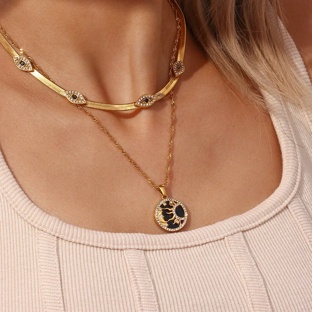 Layered 18K gold necklaces worn on model including evil eye herringbone choker and round pendant necklace styling inspiration