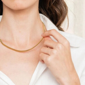 Slim twisted 18K gold chain necklace worn on neck close-up portrait with white collared shirt minimalist style