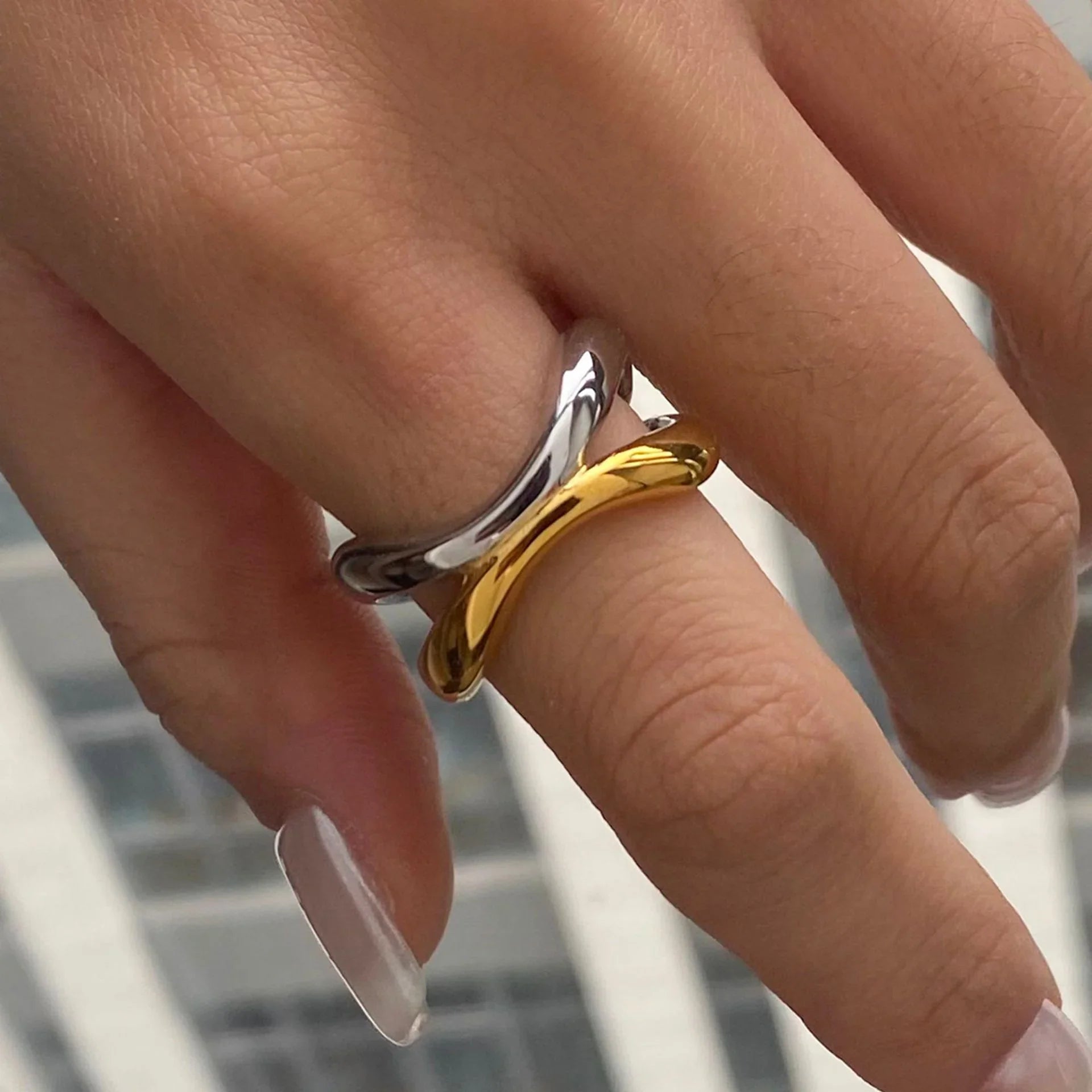 18K gold two-tone intertwined ring fitted on female fingers, demonstrating comfortable adjustable wear