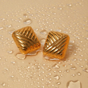 18K gold geometric square earrings polished finish water droplets durability test top-down view