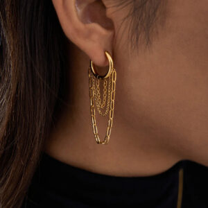 18K gold chain huggie hoop earrings worn on ear close-up side view showing multi-strand gold chain dangles and secure huggie fitting on model with dark hair