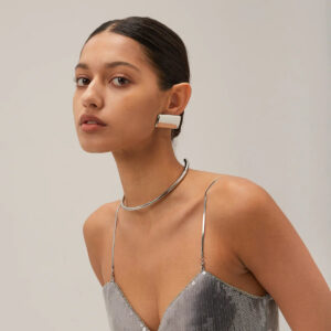 Silver rectangular ear cuff earrings styled on model wearing sequin camisole, contemporary geometric jewelry in studio setting