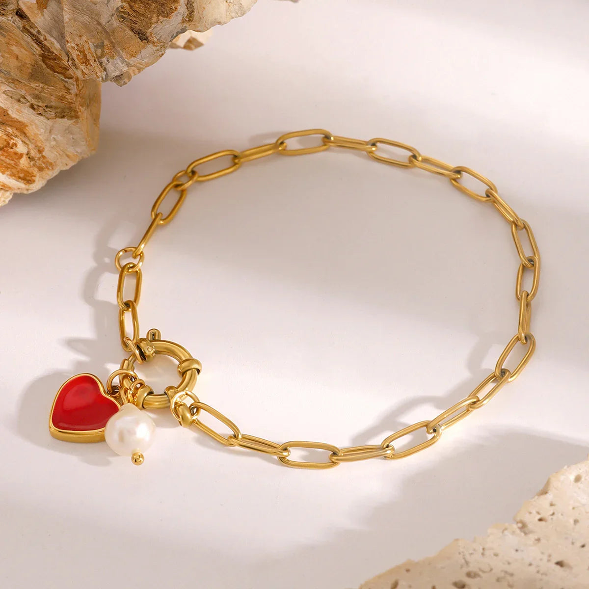 18K gold bracelet front flat lay with stone decor - clear view of spring ring clasp and dangling heart and pearl charms
