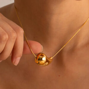 Gold teardrop drop pendant necklace worn on model - close-up neck detail showing high-shine finish and adjustable chain