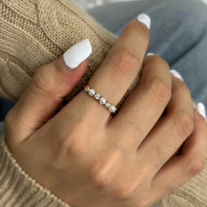 18k pearl diamond gold ring on female hand with white manicure close-up overhead detail shot showing gemstone brilliance