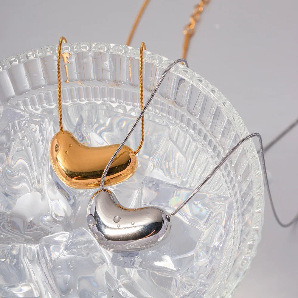 mixed metal bean pendant necklaces gold and silver matching pair top down close-up decorative tray