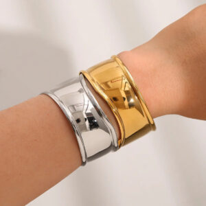 Dual-tone 18K gold and silver cuff bangles worn on wrist showing mixed metal stackable design