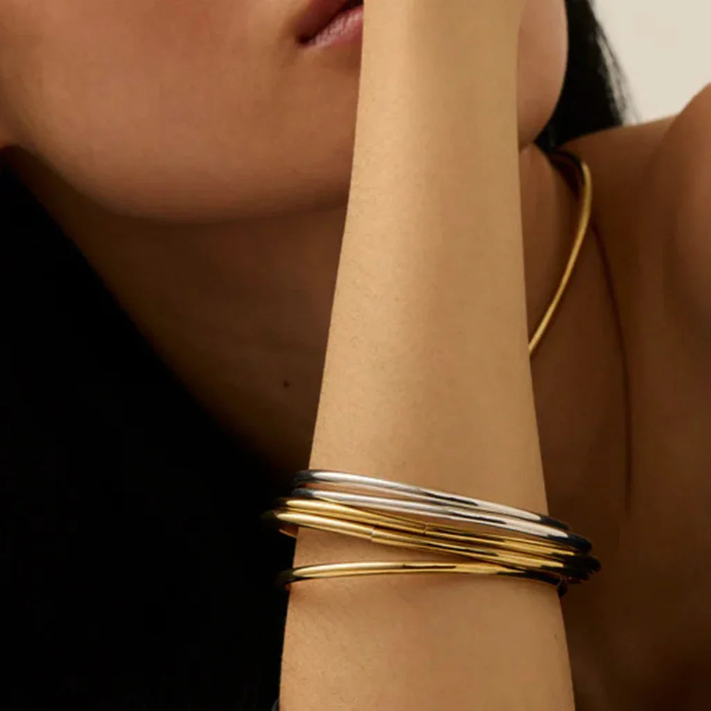 Dual-tone stacked bangles - mixed 18K gold and silver thin bracelets on wrist