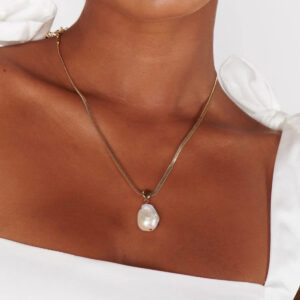 baroque pearl herringbone necklace worn on neck upper body close-up model white off-shoulder top