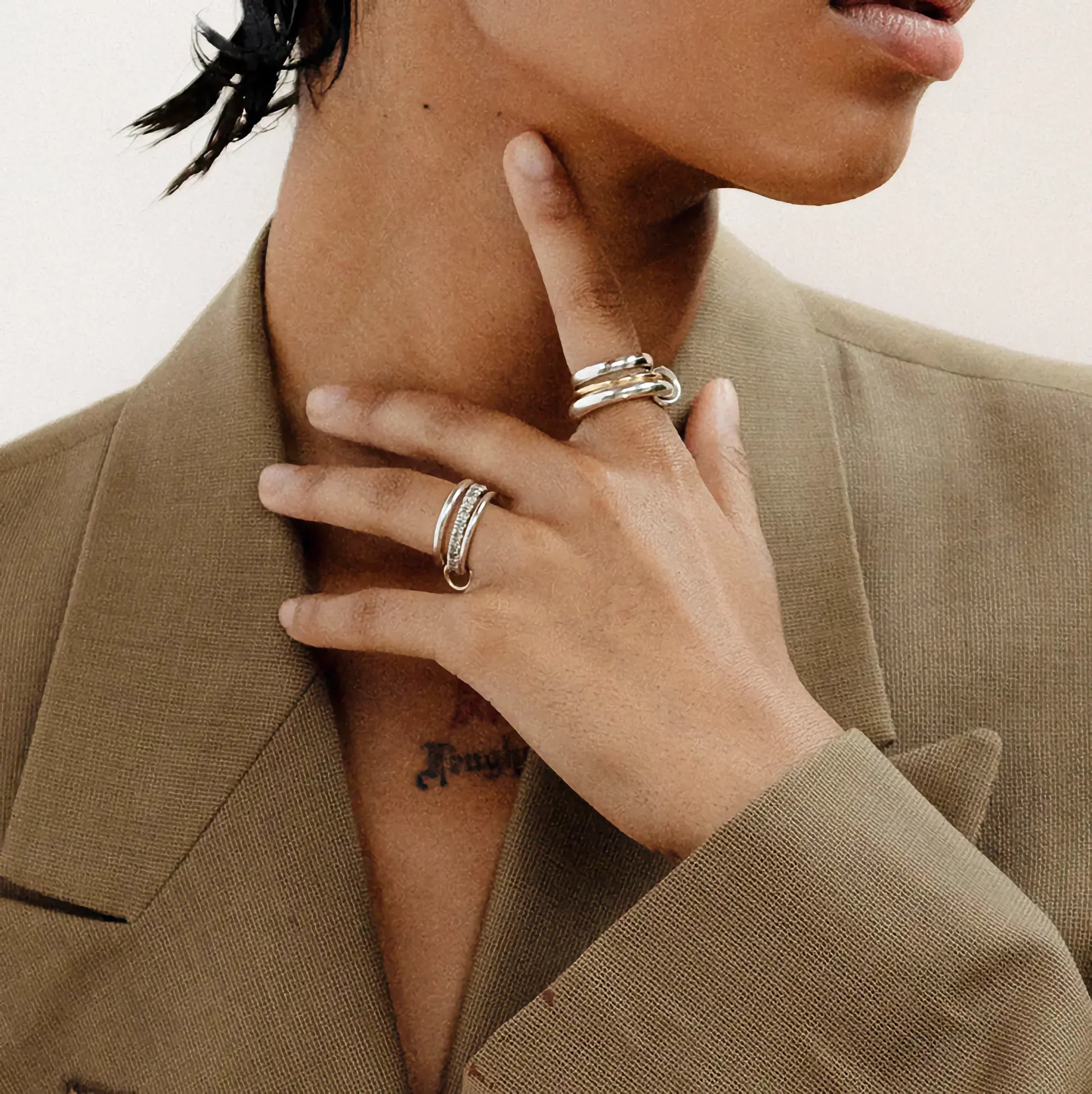 Stacked two-tone ring set worn on hand - close-up view showing 18K gold and silver bands with polished finish on fingers