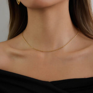 Minimalist 18K gold chain necklace worn on neck - dainty slim design paired with black off-shoulder top for sophisticated style