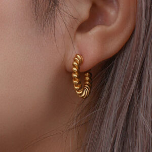 18K Gold Twisted Earrings worn on ear - close-up shot showing twisted texture and shine on female model