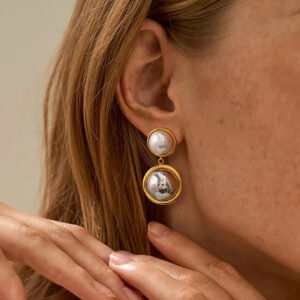 18K gold pearl dome drop earrings worn on model - close-up side ear profile showing elegant dual pearl drop design with gold bezels
