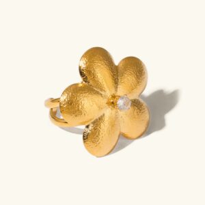 18K gold flower petal statement ring with cubic zirconia center stone displayed on plain background, showcasing five-petal design and textured gold finish