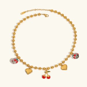 18K gold heart and cherry charm necklace flat lay, featuring polished gold beaded chain with heart pendants and enamel cherry accents on white background