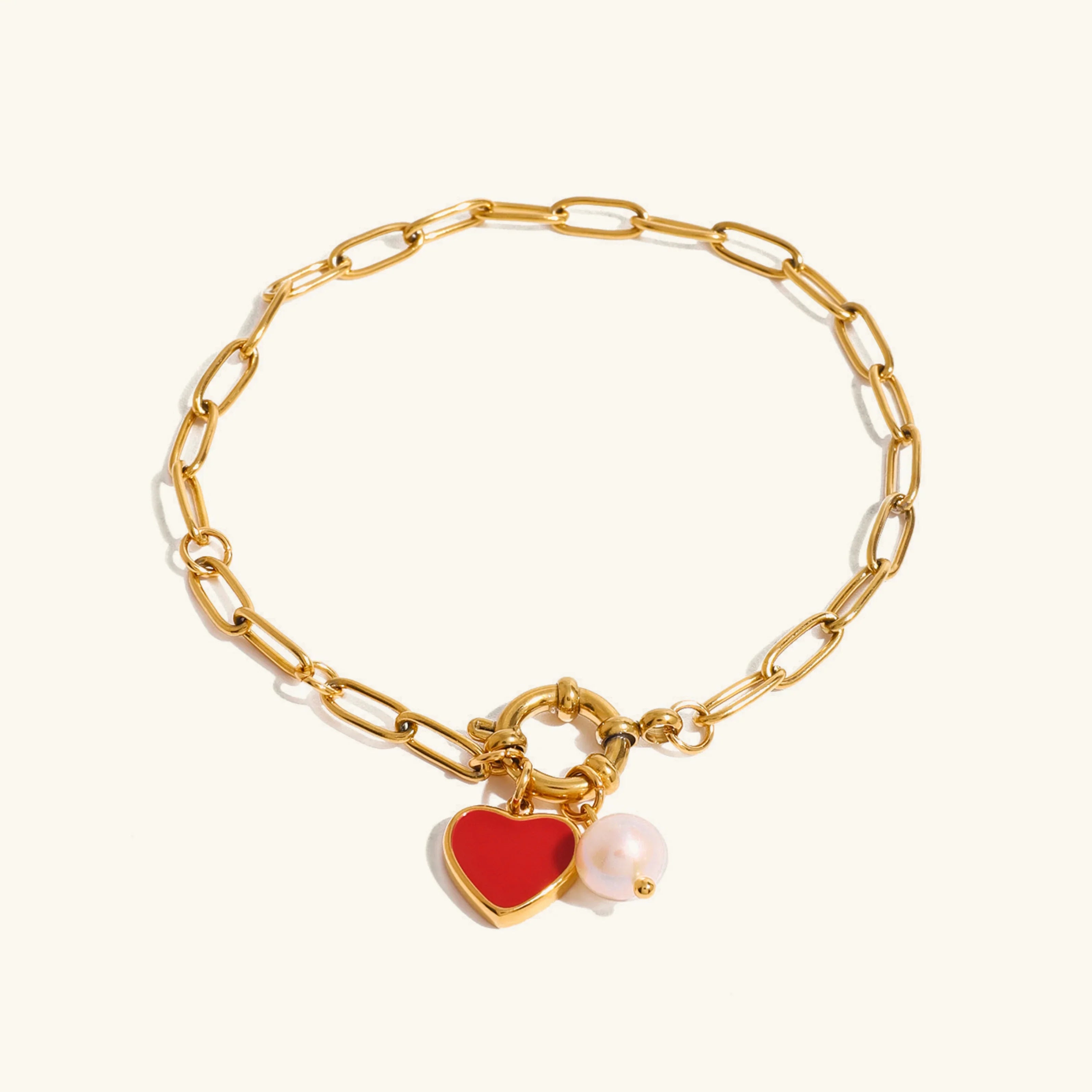 18K gold heart pearl charm bracelet with paperclip chain - flat lay on white background showing full design