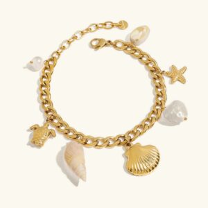 18K gold freshwater pearl ocean charm bracelet flat lay on plain background featuring curb chain with sea-themed charms and baroque pearls