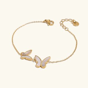 18K gold butterfly pearl bracelet flat lay with dual mother-of-pearl butterfly charms on adjustable gold chain