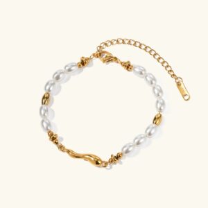18K gold freshwater pearl bracelet flat lay featuring creamy white oval pearls with twisted gold metal accents on plain background