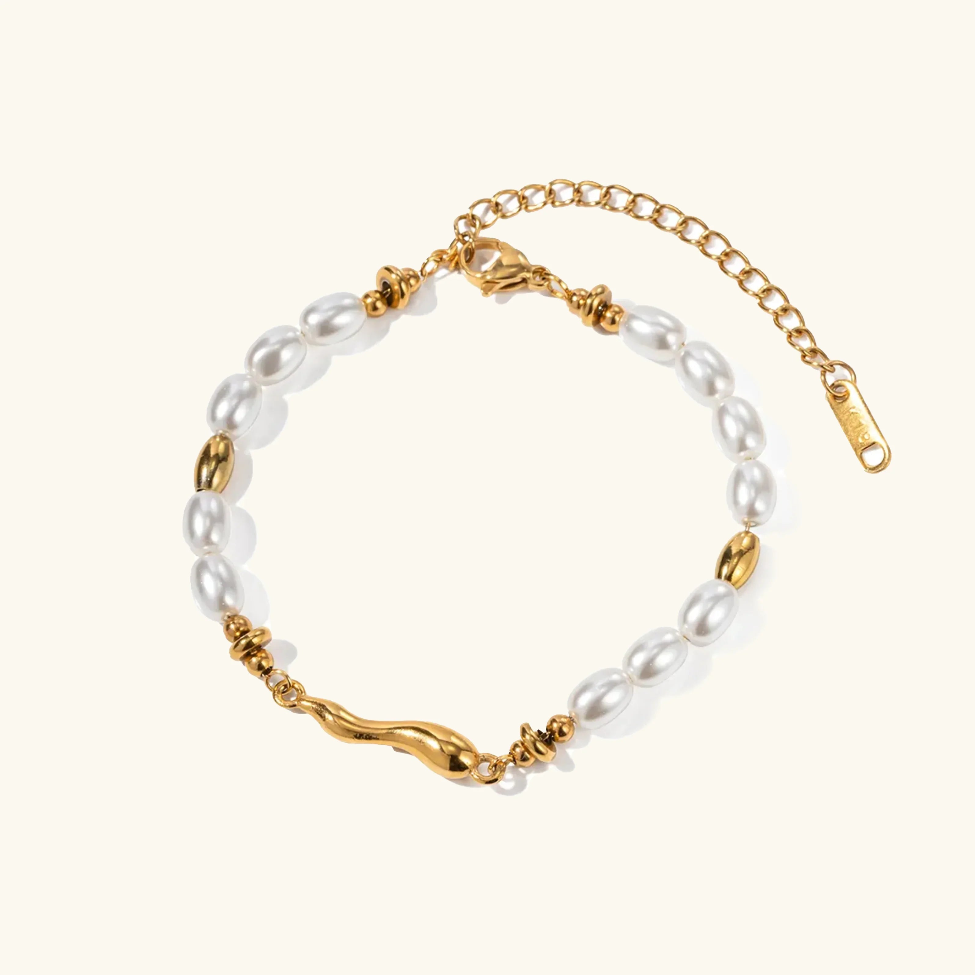18K gold freshwater pearl bracelet flat lay featuring creamy white oval pearls with twisted gold metal accents on plain background