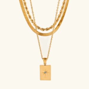 18K gold layered necklace set with starburst pendant flat lay top view