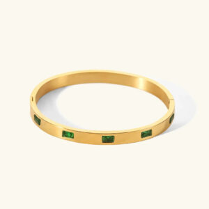 18K gold rectangular emerald bangle bracelet flat lay top view polished gold finish with green stone inlays luxury jewelry